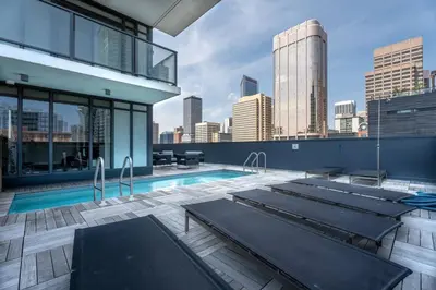 a pool on top of a building with a city skyline at Elegant, Comfy & Sophisticated MetroLux Downtown Suite in Calgary