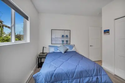a bedroom with a blue bed and a window at Pure Paradise in Prince George