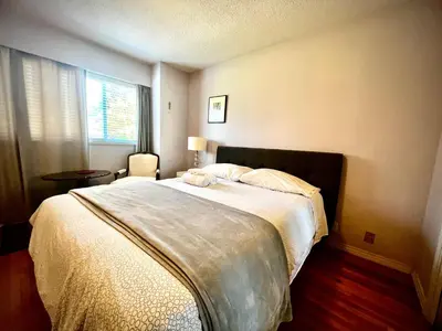 a bedroom with a large bed and a window at Spacious place Close to UBC -1 in Vancouver