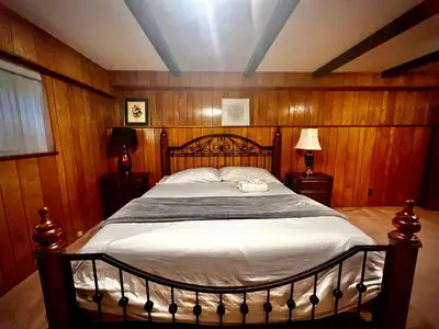 a bedroom with a large bed with wooden walls at Spacious place Close to UBC -1 in Vancouver