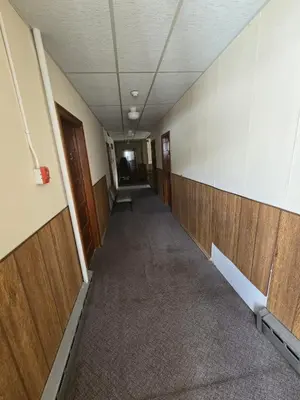 an empty hallway in an office building with wooden walls at Coal Branch Hotel & Restaurant