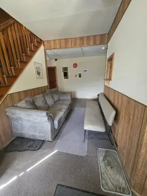 a living room with a couch and a staircase at Coal Branch Hotel & Restaurant