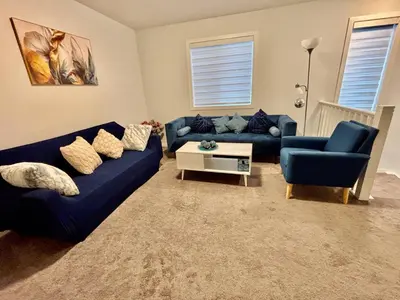 a living room with a blue couch and two chairs at Zillion’s Joy in Calgary
