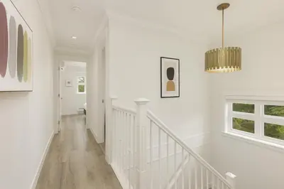 a white hallway with a staircase and a chandelier at Spacious 4BD Home in Vancouver in Vancouver