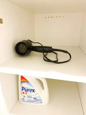 a hair dryer sitting on a shelf with a box of juice at 5 Min to Southgate Mall and U of A, Bright and Private, Cool Summer Stay in Edmonton