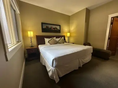 a bedroom with a large white bed and a window at Solara 2BR Retreat - Pool - Hot Tub & Resort Perks in Canmore