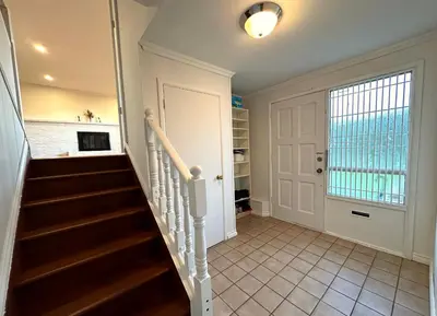 a staircase in a home with a white door at Spacious 5 Bedroom House Near YVR Airport, Transit & Shopping in Richmond
