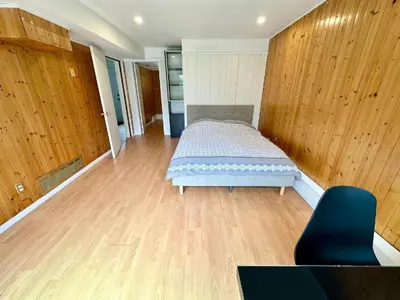 a bedroom with a bed and a wooden wall at Spacious 5 Bedroom House Near YVR Airport, Transit & Shopping in Richmond