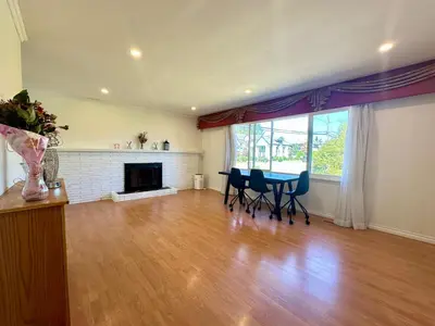 a living room with a table and chairs and a fireplace at Beautiful Place with Kitchen, Washing Machine and Internet Near YVR Airport, Transit and Shopping Mall in Richmond