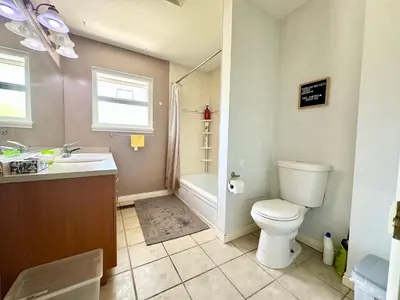 a bathroom with a toilet and a sink and a tub at Beautiful Place with Kitchen, Washing Machine and Internet Near YVR Airport, Transit and Shopping Mall in Richmond