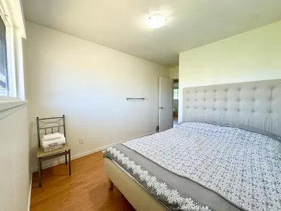 a bedroom with a large bed and a window at Beautiful Place with Kitchen, Washing Machine and Internet Near YVR Airport, Transit and Shopping Mall in Richmond
