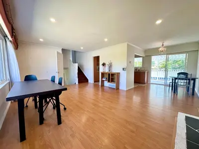 a large living room with a table and a kitchen at 2 Bedrooms Garden Suite with Living Room, Kitchen and Laundry near YVR Airport, Transit and Shopping Mall in Richmond