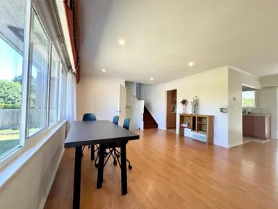 a dining room with a table and a kitchen at 2 Bedrooms Garden Suite with Living Room, Kitchen and Laundry near YVR Airport, Transit and Shopping Mall in Richmond
