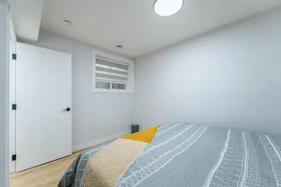 a bedroom with a bed and a window at New 1 bdr basement apartment in Calgary