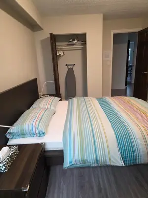 a bedroom with a bed with a dresser and a mirror at Maplewood Hostel in Vancouver