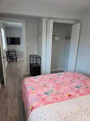 a bedroom with a bed with a pink blanket at Maplewood Hostel in Vancouver