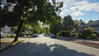 a street with cars parked on the side of the road at Maplewood Hostel in Vancouver