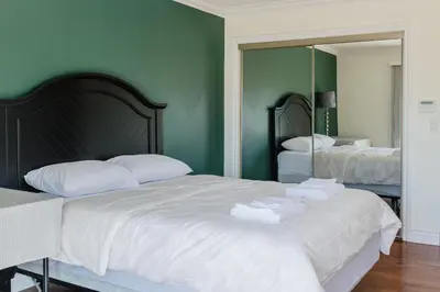 a bedroom with two beds with white sheets and a mirror at Serene 3BR Cabin on 8 Acre Farm in Mission City