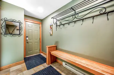 a hallway with a wooden bench next to a door at Treetops Ski Luxury Townhouse in Big White
