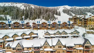a resort in the snow with snow covered roofs at Treetops Ski Luxury Townhouse in Big White
