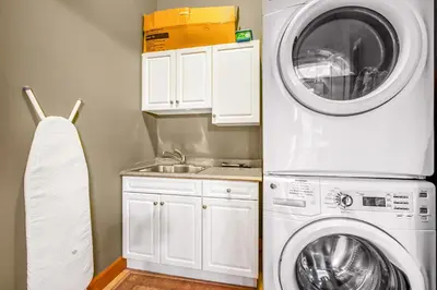 a kitchen with a washing machine and a sink at Treetops Ski Luxury Townhouse in Big White