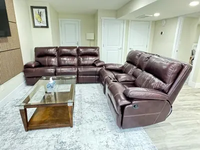 a brown leather couch and a table in a living room at Annas Suites Rental in Bélanger