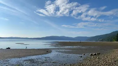 a beach with a view of the water and mountains at Beachbreeze Panoramic Oceanview 5BR 4BA Romantic Sunrise & Celestial Views in Mill Bay