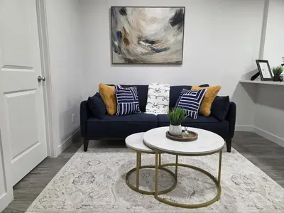 a living room with a blue couch and a table at Modern 2BR near Hospital, YMCA, Stores in Calgary