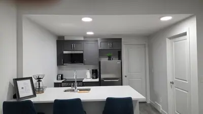 a kitchen with a white counter and a refrigerator at Modern 2BR near Hospital, YMCA, Stores in Calgary