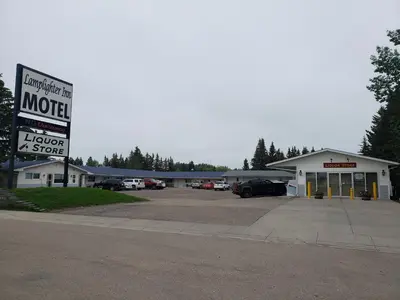 a motel with a sign in a parking lot at Lamplighter Inn in Three Hills