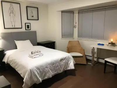 a bedroom with a white bed and a table and a desk at Vancouver Richmond Villa 32 in Richmond