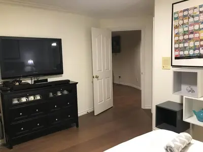 a living room with a flat screen tv on a dresser at Vancouver Richmond Villa 32 in Richmond
