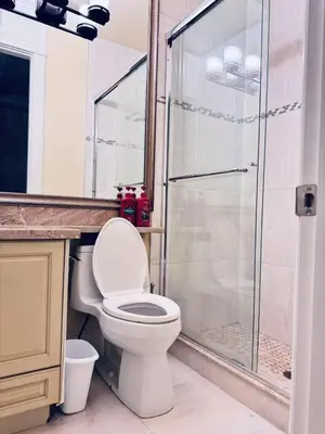 a bathroom with a toilet and a glass shower at Vancouver Richmond Villa 32 in Richmond