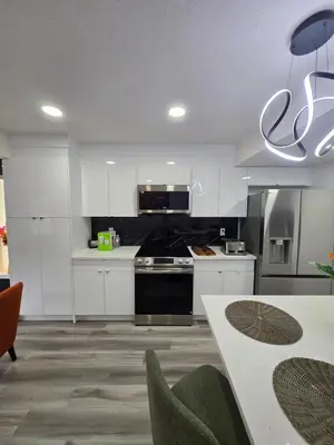 a kitchen with white cabinets and a black stove at The Walkout at the Ravine in Edmonton