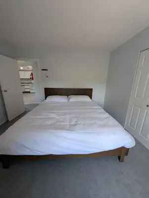 a bedroom with a large bed with white sheets at Alert Bay, Spacious Executive Suite with Panoramic Ocean Views in Alert Bay