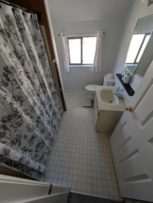 a bathroom with a sink and a shower curtain at Alert Bay, Spacious Executive Suite with Panoramic Ocean Views in Alert Bay