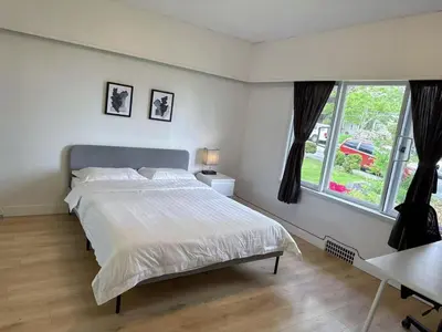 a bedroom with a large bed and a window at Vancouver Burnaby Villa 36 in Burnaby