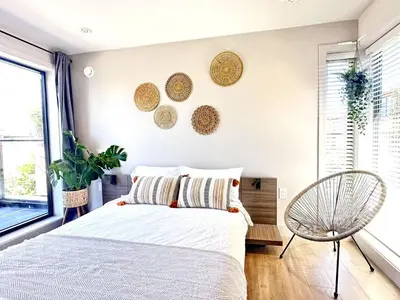 a bedroom with a bed and a chair at Vancouver Westside Villa 37 in Vancouver