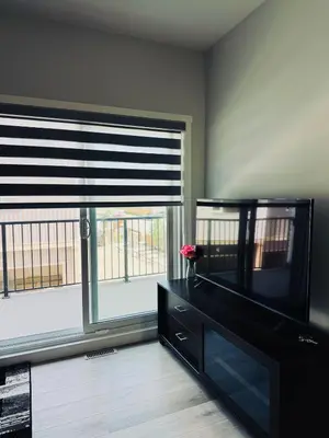a living room with a television and a window at Cozy house with 4 Bedrooms 3 Full bath and 1 half bath in Calgary