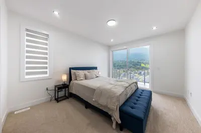 a white bedroom with a bed and a window at Luxury Home in Victoria