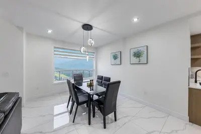 a dining room with a table and chairs and a window at Luxury Home in Victoria