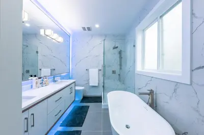 a white bathroom with a tub and a sink at Luxury Home in Victoria