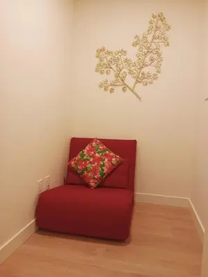 a red couch with a pillow on a wall at New condo Great amenities Near Skytrain in Coquitlam