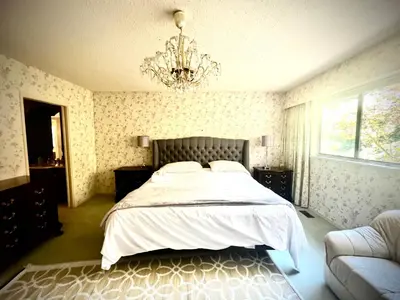 a bedroom with a bed and a chandelier at Luxury Space close to UBC in Vancouver