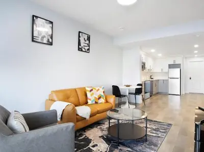a living room with a couch and a table at Olympia Lodge 2 room Apartment in Calgary
