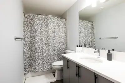 a bathroom with a sink and a toilet and a shower at Olympia Lodge 2 room Apartment in Calgary