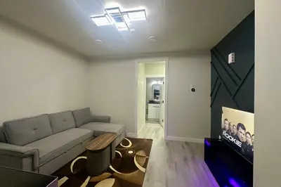 a living room with a couch and a tv at Cozy 2BR Retreat - 10 Mins to WEM - Free Parking & WiFi in Edmonton