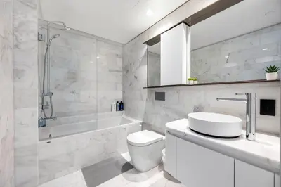 a bathroom with a toilet and a tub and a sink at Urban Retreat 2BR Condo with Stunning City View in Vancouver