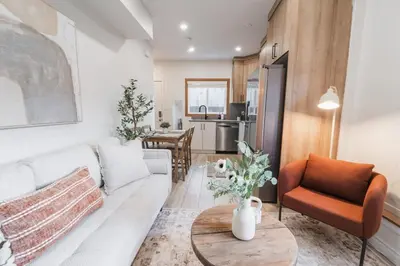 a living room with a white couch and a table at Chic Garden Suite Hideaway 2Bedroom Games Room in Edmonton