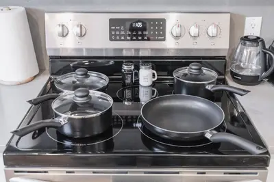a stove with pots and pans on top of it at Chic Garden Suite Hideaway 2Bedroom Games Room in Edmonton